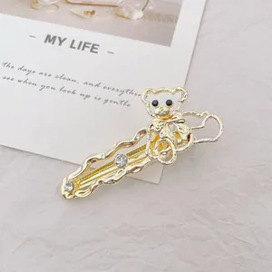 Detalle de pinza para el pelo con oso dorado, lazo, diamantes de imitación y diseño