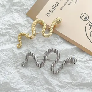 Exquisite gold and silver snake shaped metal brooches with textured scale patterns