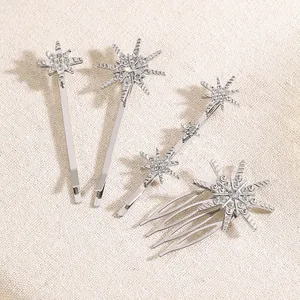 Detail von vier silbernen Haarklammern mit funkelnden Strasssternen und Schneeflocken