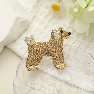 Detalle de broche de caniche con cristales marrones sobre una base de metal dorado