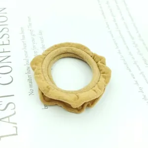 Detail of khaki pleated scrunchie with ruffled edges on a stylish magazine background