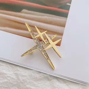 Élégante broche double étoile dorée avec strass scintillants et une finition polie