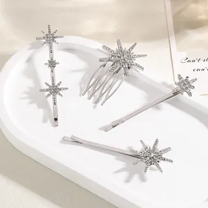 Detailsicht auf silberne Strass-Haarspangen und Kamm mit Sternen auf weißem Tablett