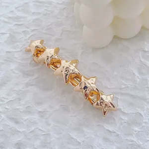 Détail d'une élégante barrette étoile dorée sur fond blanc texturé avec décoration