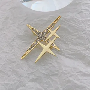 Détail d'une broche étoile dorée avec strass cristallins et design géométrique poli