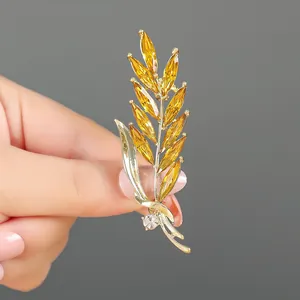 Elegante spilla a spiga di grano dorata con gemme marquise gialle e strass lucidi