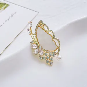 Eleganter Schmetterling-Brosche mit Goldrahmen, weißen Flügeln, grünen Steinen und Perle