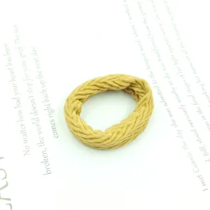 Macro detail of mustard yellow woven hair tie showing high-elasticity braided texture