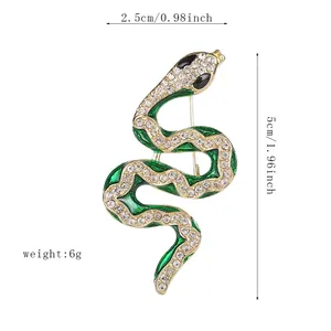 Detail of green enamel snake brooch with gold lines and dimensions 2.5x5cm