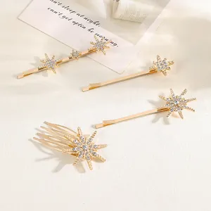 Nahaufnahme goldener Haarspangen mit Strasssteinen und ein passender dekorativer Haarkamm
