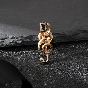Dettaglio macro spilla musicale dorata con chiave di violino e design microfono retrò