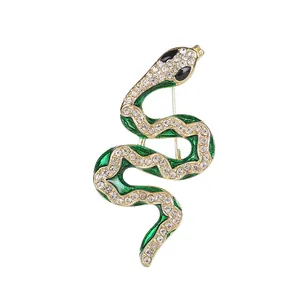 Elegant green enamel snake brooch with white crystals and gold plating on a white background