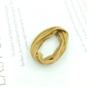 Close-up of brown textured elastic hair tie on a book page with high elasticity detail