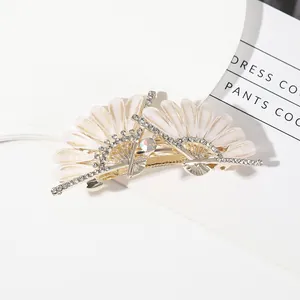 Elegant fan-shaped gold hair claw clip with pearlescent shell slices and white rhinestones