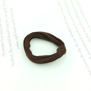 Close-up of a dark coffee brown velvet seamless hair tie on minimalist literary paper