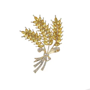 Elegante spilla a spiga di grano dorata con cristalli gialli e fiocco di strass