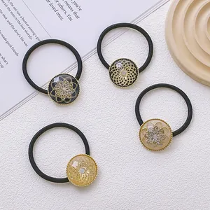 Lot de quatre chouchous fleurs en strass dorés et noirs au design vintage élégant