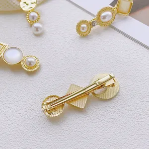 Elegant gold alloy hair clips featuring white faux pearls and iridescent cat eye stones