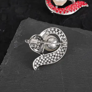 Silver fox brooch back view with faux pearl inlay on dark slate stone background