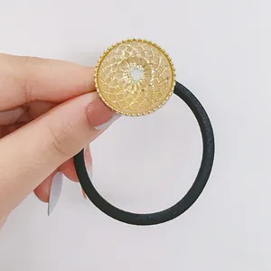 Gros plan sur un chouchou floral en strass avec détail de grille métallique dorée
