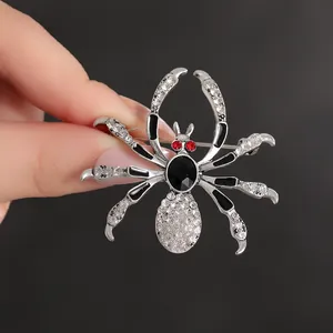 Gothic spider brooch with white rhinestones and black gem on silver metal base