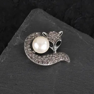 Elegant fox brooch with a large central pearl and sparkling rhinestones on stone base