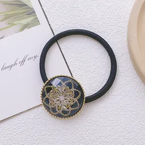 Gros plan sur un élastique à cheveux vintage avec un pendentif floral bleu foncé
