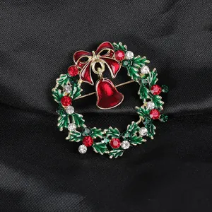 Détail de la broche couronne de Noël avec feuilles d'émail et petite cloche rouge