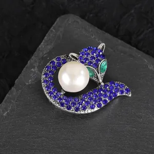 Detailed close-up of a silver fox brooch with blue rhinestones and a white pearl