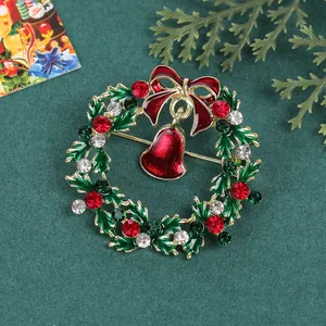 Détail d'une broche couronne de Noël festive avec strass colorés sur un tissu vert