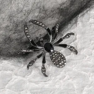 Detailed macro view of a vintage dark spider brooch with black gems and grey rhinestones