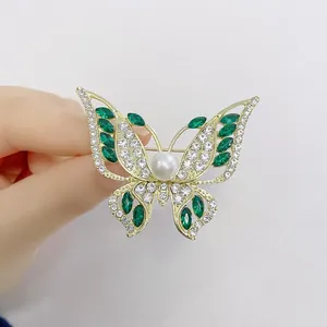Elegant gold-plated butterfly brooch with emerald crystals and white pearls