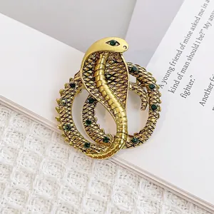 Detailansicht der Vintage Cobra-Brosche in Gold mit grünen Steinen und Schuppentextur