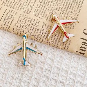 Broches en émail en forme d'avion en rouge et bleu sur fond de journal vintage