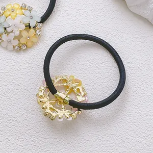 Détail d'élastique à cheveux avec fleurs en strass colorés et clips dorés brillants