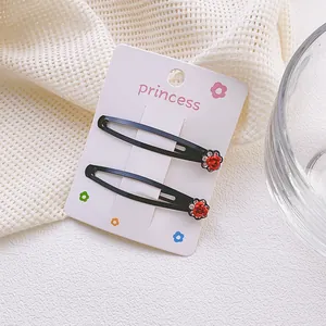 Detalle de horquillas negras con forma de gota, rosas rojas y pequeños brillantes