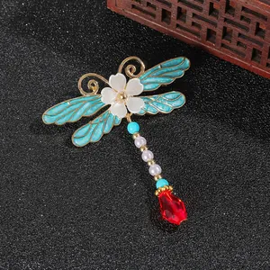Eleganter Libellen-Anstecknadel mit blauer Emaille und Edelstein auf schwarzem Hintergrund