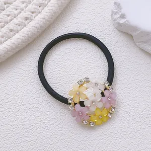 Détail d'un chouchou noir élastique avec fleurs givrées et petits strass brillants