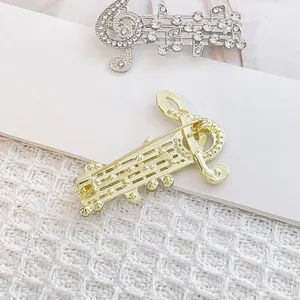 Spille eleganti a forma di nota musicale con strass luccicanti in argento e oro