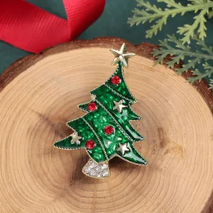 Vue macro de la broche sapin de Noël en émail vert et strass rouges sur support bois