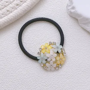 Gros plan sur un élastique à fleurs avec pétales mats pastel et détails en strass