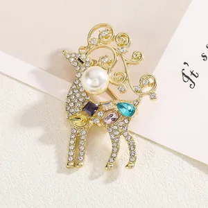 Vue macro détaillée d'une broche de renne dorée avec gemmes multicolores et grande perle