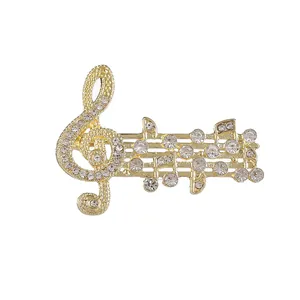 Elegante spilla a nota musicale dorata con strass scintillanti e chiave di violino