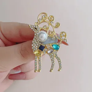 Détail de broche renne avec cristaux blancs, pierres colorées et perle de culture
