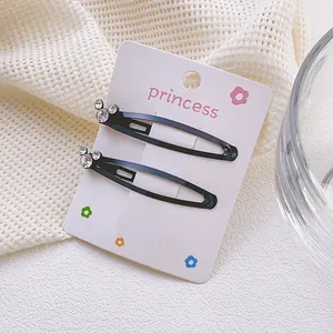 Detalle de pinzas para el cabello en metal negro con brillantes decoraciones de strass