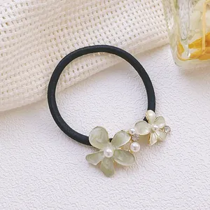 Vue détaillée d'un chouchou floral avec des strass et des perles élégantes pour cheveux