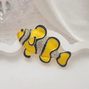 Exquisito broche de pez payaso tropical con esmalte amarillo y pedrería blanca sobre oro