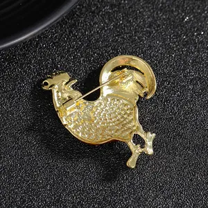 Back view of gold-tone alloy rooster brooch showing the pin buckle and texture