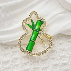 Detail of emerald green bamboo gourd brooch with sparkling crystals and gold finish