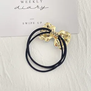 Eleganter goldener Haargummi mit Kristallschleife und schwarzem elastischem Band
